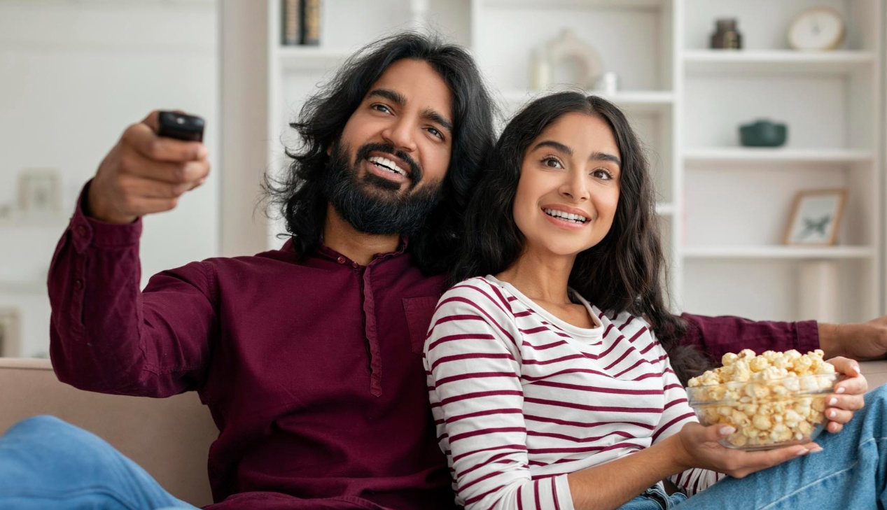Couple watching Hathway Digital Cable TV with popcorn